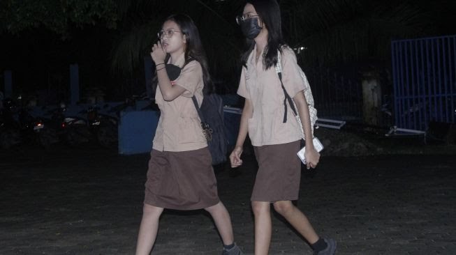 foto :Para pejalar Sekolah Menengah Atas (SMA) yang terlambat tiba di halaman SMA Negeri I Kupang di Kota Kupang, NTT, Rabu (1/3/2023).[ANTARA FOTO/Kornelis Kaha].